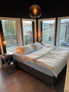 a bedroom with a large bed with windows at Moderne enebolig med gratis parkering in Alta