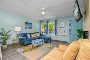 a living room with blue walls and a blue couch at Latitude 26 Waterfront Boutique Resort - Fort Myers Beach in Fort Myers Beach
