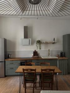 a kitchen with a wooden table and chairs in a kitchen at L'Écrin in Béziers