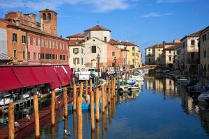 a canal in a city with boats and buildings at Cà in Laguna in Chioggia