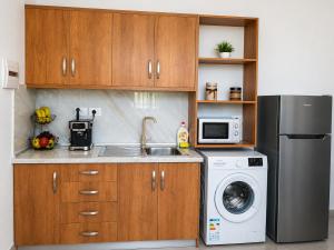a kitchen with a sink and a refrigerator at The Pine House in Fier +5 photos