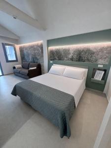 a bedroom with a large bed and a couch at Cà in Laguna in Chioggia