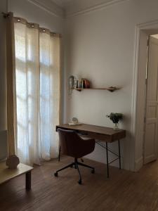 a desk and a chair in a room with a window at L'Écrin in Béziers +3 photos