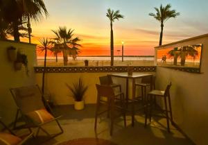 a table and chairs on a balcony with a view of the beach at Arenas de Sanlúcar II in Sanlúcar de Barrameda