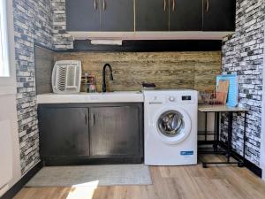 a kitchen with a washing machine and a sink at Le calme de la campagne proximité Center Parcs in Saint-Léger-de-Montbrillais +20 photos