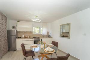 a kitchen and dining room with a table and chairs at Villa Green Bay in Vela Luka