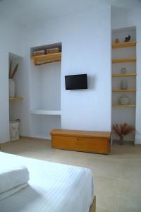 a bedroom with a bed and a tv on a wall at To Nisi in Loutraki