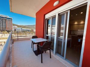 a patio with a table and chairs on a balcony at Thoma's K Studios in Vlorë