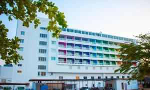 ein großes weißes Gebäude mit bunten Fenstern in der Unterkunft LEBENE Hotel in Lomé
