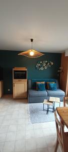 a living room with a blue couch and a table at Chez Nathalie - Appartement cosy- Multi pass offert- Draps, serviettes et ménage compris in Saint-Jean-d'Aulps