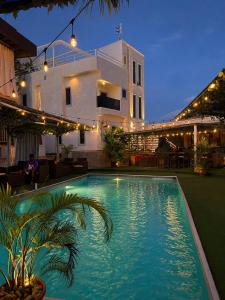 a swimming pool in front of a house at night at DE Lounge Inn in Ikorodu