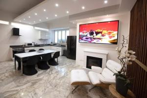 a living room with a kitchen with a tv on the wall at La Galleria Milano - 160 sqm Design Apartment, Spa & Parking in Milan