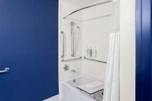 a bathroom with a bath tub with a shower curtain at Spark By Hilton Beckley in Beckley +14 photos