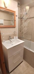 a white bathroom with a sink and a shower at Chez Nathalie - Appartement cosy- Multi pass offert- Draps, serviettes et ménage compris in Saint-Jean-d'Aulps +37 photos