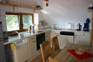 a kitchen with white cabinets and a wooden table at Boddenbrise in Born