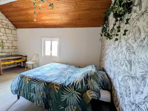a bedroom with a bed in a room with a wooden ceiling at Le calme de la campagne proximité Center Parcs in Saint-Léger-de-Montbrillais