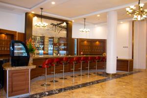 eine Bar mit roten Barhockern in einem Raum in der Unterkunft LEBENE Hotel in Lomé