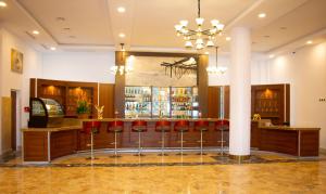Eine Bar mit roten Barhockern in einer Hotellobby in der Unterkunft LEBENE Hotel in Lomé