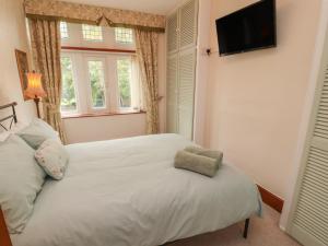 a bedroom with a white bed and a television on the wall at The Haven in Morecambe