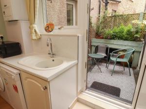 a bathroom with a sink and a patio with a chair at The Haven in Morecambe +19 photos
