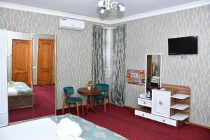 a room with a bed and a table and chairs at Old Town Hotel in Baku