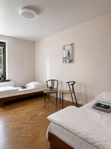 a white room with two beds and a table at Hotel Gryf in Gryfice