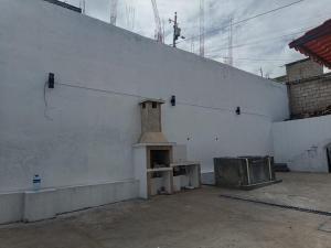 a white wall with a small stove in a room at Casa en Sur de Quito in Quito