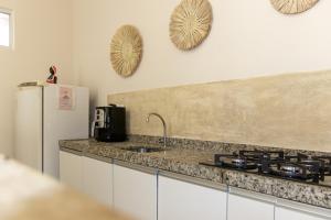a kitchen with a stove and a refrigerator at Green Paradise Canoa Quebrada in Canoa Quebrada