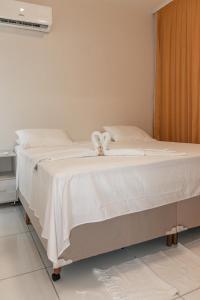 a white bed with a bow on top of it at Green Paradise Canoa Quebrada in Canoa Quebrada