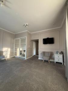 a living room with a flat screen tv on the wall at Szafirowy Dwór Hotel & Restauracja in Gliwice