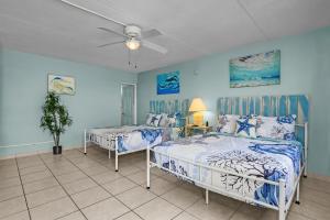 a bedroom with two beds and a ceiling fan at Latitude 26 Waterfront Boutique Resort - Fort Myers Beach in Fort Myers Beach +80 photos
