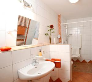 a white bathroom with a sink and a mirror at Ferienwohnungen Holder in Anhausen +41 photos