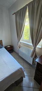 a bedroom with a bed and a window at Apartments Hugo in Malinska