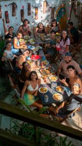 a group of people sitting around a table eating food at Pipa Surf House in Pipa
