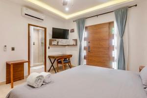 a bedroom with a bed and a desk and a television at Akbal Cancun in Cancún