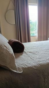 a pillow sitting on top of a bed with a window at Suíte caripi in Barcarena