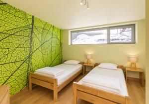 two beds in a room with a green wall at Au Bailet in Gedinne