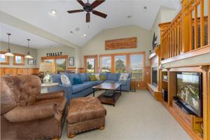 a living room with a blue couch and a tv at VOH151 FINALLY in Corolla