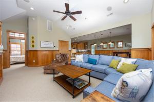 a living room with a blue couch and a table at VOH151 FINALLY in Corolla +140 photos