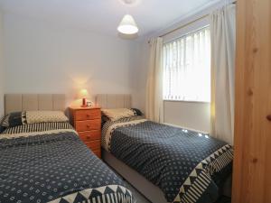 a bedroom with two twin beds and a window at 51 Colin McLean Road in East Dereham
