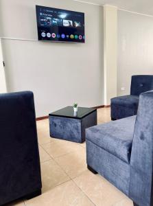 a living room with two chairs and a coffee table at Centrica y Residencial in Ambato