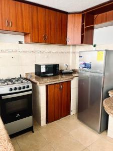 a kitchen with a stove and a refrigerator at Centrica y Residencial in Ambato