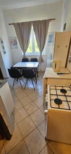 a kitchen with a stove and a table with chairs at Apartments Hugo in Malinska