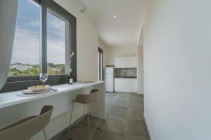 a kitchen with a counter with chairs and a window at La dimora del cavatore in Favignana
