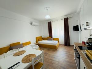 a kitchen and a living room with a couch and a table at The Gwen in Sarandë