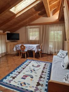 a living room with a table and a rug at Casa Campetta in Comano Terme