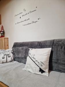 a bed with a pillow and words on the wall at Casa Campetta in Comano Terme