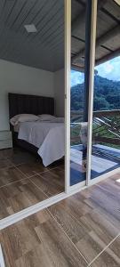 a bedroom with a bed and sliding glass doors at La cabañita VIP in Minca