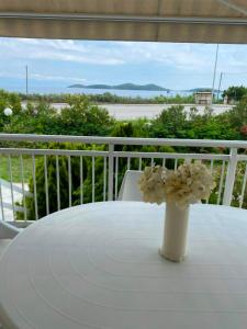 a vase with flowers sitting on a table on a balcony at Dream house Peramos in Nea Peramos