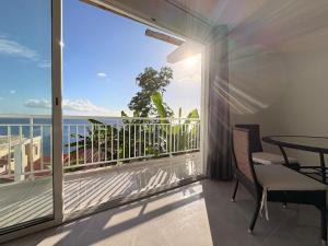 a balcony with a table and a view of the ocean at Les Terrasses du Fort in Basse-Terre